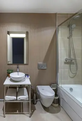 a bathroom with a sink and a toilet and a shower at Upsuites Hotel in Istanbul