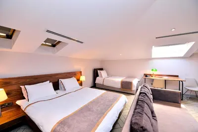 a hotel room with two beds and a desk at Upsuites Hotel in Istanbul