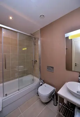 a bathroom with a shower and a toilet and a sink at Upsuites Hotel in Istanbul