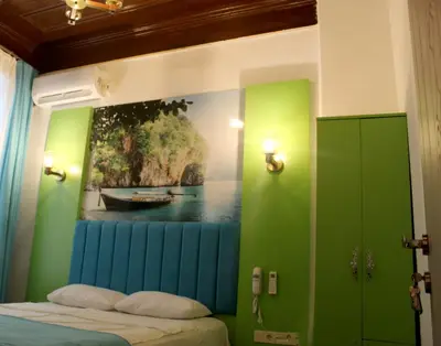 a bedroom with a painting of a boat on the wall at HOTEL MİKLAGORD in Istanbul