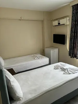 a room with two beds and a tv in it at Hotel Wiva in Istanbul