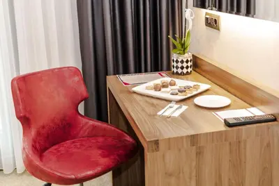 a red chair sitting in front of a desk at Ramada by Wyndham Beylikduzu in Istanbul