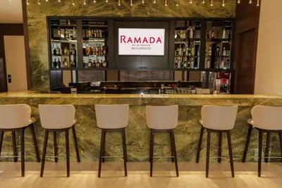 a bar at a hotel with white stools at Ramada by Wyndham Beylikduzu in Istanbul