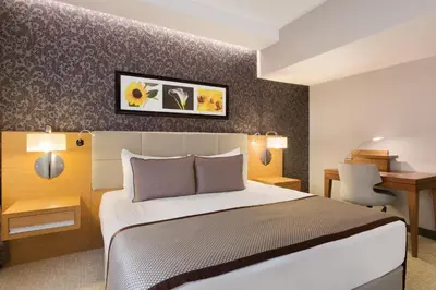 a hotel room with a bed and a desk at Ramada Plaza By Wyndham Izmit in Kocaeli