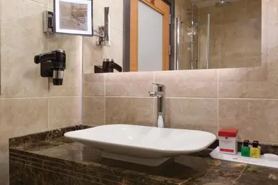 a bathroom with a white sink on a counter at Ramada Plaza By Wyndham Izmit in Kocaeli