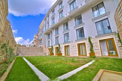 a large white building with a lawn in front of it at Yılsam Sultanahmet Hotel in Istanbul