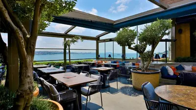 a restaurant with tables and chairs and a view of the ocean at Zimmer Bosphorus Hotel in Istanbul