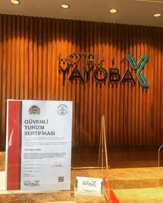 a sign in front of a wooden wall at Hotel Yayoba in Tekirdag