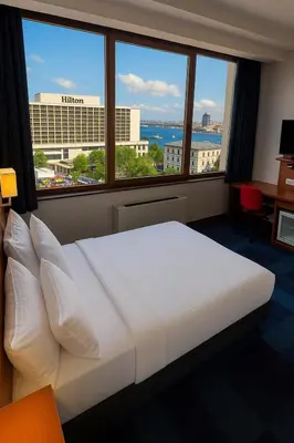 a bedroom with a large bed with a large window at Taxim Express Bosphorus Hotel in Istanbul