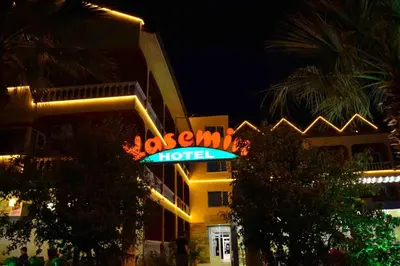 a hotel with a neon sign in front of it at Hotel Yasemin in Erdek