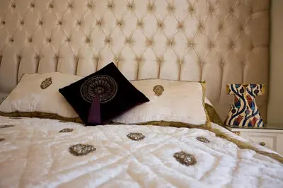 a bed with a white quilt with a purple pillow at Ersari Hotel in Istanbul