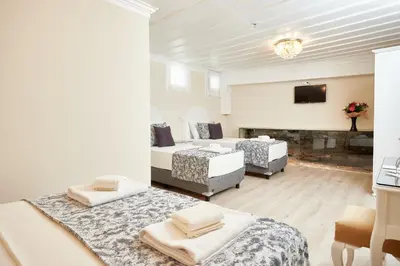 a room with three beds and a television in it at Mataraci Konak in Istanbul