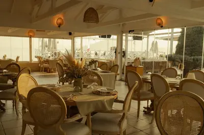 a dining room with tables and chairs and windows at Lale Hotel in Sapanca