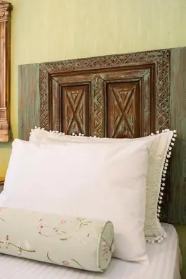 a bed with a wooden head board and white pillows at Ajda Haus Nisantasi in Istanbul