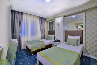 a hotel room with two beds and a window at Monaco Hotel in Istanbul