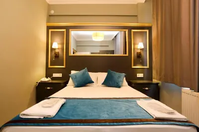 a bedroom with a bed with a mirror and blue pillows at Grand Moon Hotel Suites in Istanbul