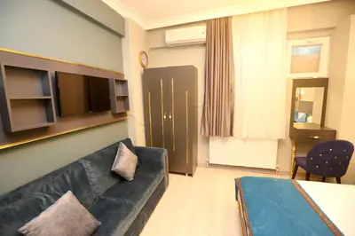 a living room with a couch and a tv at Grand Moon Hotel Suites in Istanbul