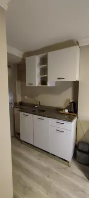 a kitchen with white cabinets and a counter top at Ortaköy Suites Hotel in Istanbul