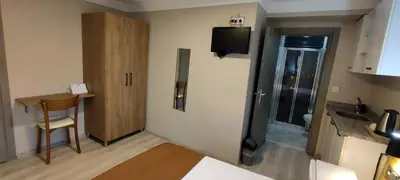 a room with a bathroom with a sink and a television at Ortaköy Suites Hotel in Istanbul