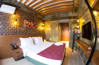 a bedroom with a large bed and a brick wall at Meydan Besiktas Hotel in Istanbul
