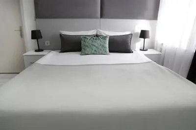a bedroom with a white bed with two lamps at Bayer Hotel in Istanbul