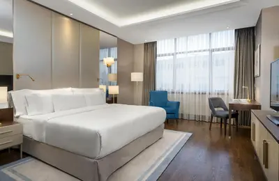 a bedroom with a large white bed and a desk at Barceló Istanbul in Istanbul