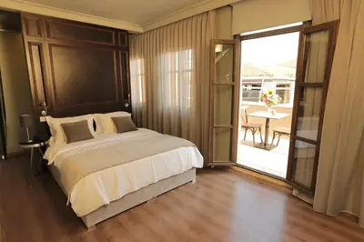 a bedroom with a bed and a balcony with a table at Ferman Pera Hotel in Istanbul