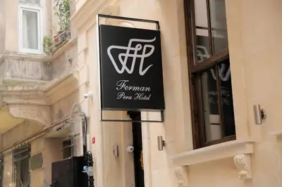 a sign for a restaurant on the side of a building at Ferman Pera Hotel in Istanbul