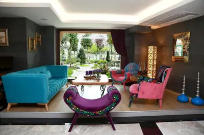 a living room with colorful chairs and a table at Tuzla Garden Hotel & Spa in Tuzla