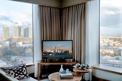 a living room with a television and a large window at Renaissance Istanbul Polat Bosphorus Hotel in Istanbul