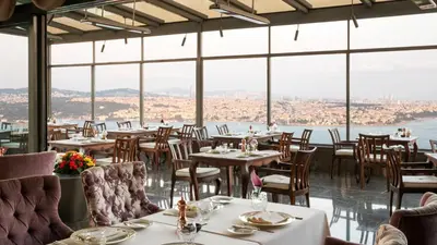 a restaurant with tables and chairs and a view of the city at InterContinental Istanbul by IHG in Istanbul
