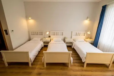 a group of four beds in a room at Eleia Hotel İznik in Bursa