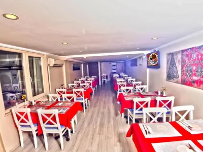a restaurant with red and white tables and chairs at Marmara Deluxe Hotel in Istanbul