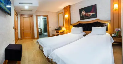 a hotel room with two beds and a table at Aprilis Hotel - Special Category in Istanbul