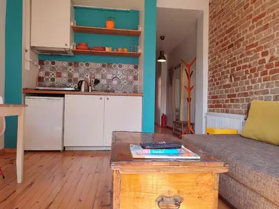a living room with a couch and a kitchen at Kunterbunt Istanbul in Istanbul