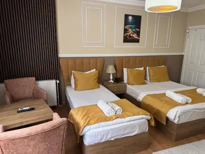 a hotel room with two beds and a chair at NEW BEYLERBEYİ HOTEL in Istanbul