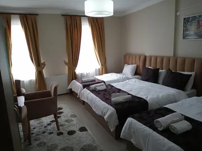 a hotel room with two beds and a chair at NEW BEYLERBEYİ HOTEL in Istanbul