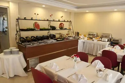 a restaurant with white tables and chairs and a buffet at Abel Hotel in Istanbul
