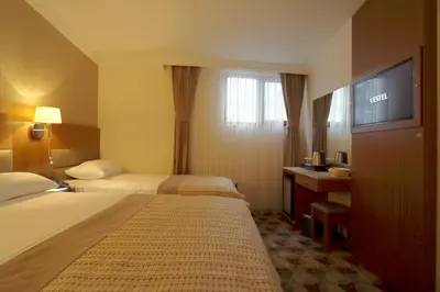 a hotel room with two beds and a flat screen tv at NL Amsterdam Hotel in Istanbul