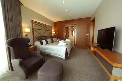 a bedroom with a bed and a tv and a chair at Cevahir Hotel Istanbul Asia in Istanbul