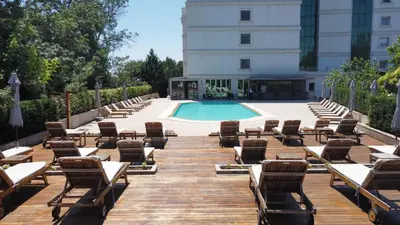 a row of lounge chairs and a swimming pool at Cevahir Hotel Istanbul Asia in Istanbul