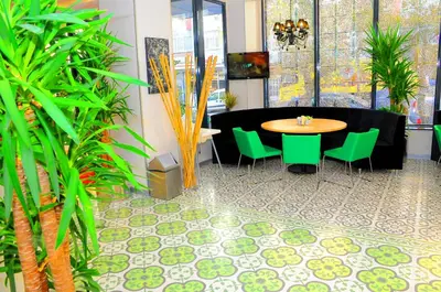 a table and green chairs in a room with plants at Tempo Hotel 4Levent in Istanbul