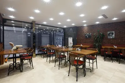 a restaurant with wooden tables and chairs and a brick wall at P Galata Hotel - Special Category in Istanbul