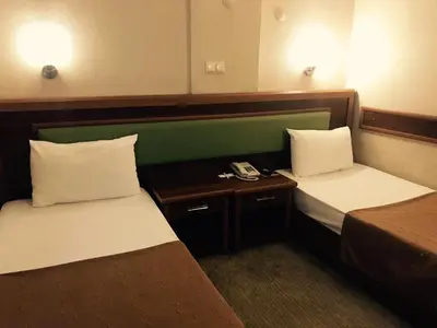 a room with two beds and a phone in it at Hotel Villa Marina in Bandırma