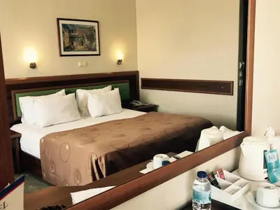 a hotel room with a bed and a large mirror at Hotel Villa Marina in Bandırma