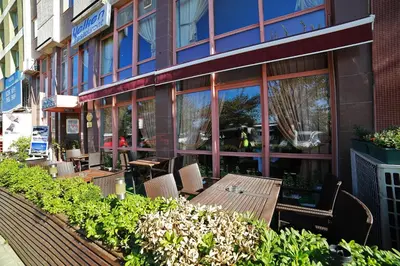 a restaurant with tables and chairs in front of a building at Hotel Villa Marina in Bandırma