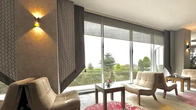 a living room with two chairs and a large window at Ramada by Wyndham Tekirdağ in Tekirdag