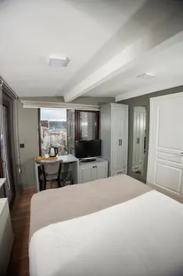 a bedroom with a bed and a desk with a television at Ortakoy Aysem Sultan Hotel in Istanbul