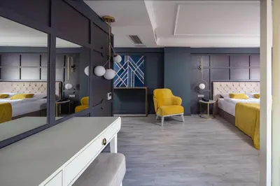 a bedroom with two beds and a yellow chair at B LOFT HOTEL in Bursa