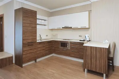 a kitchen with wooden cabinets and a white counter top at Balturk House Hotel in Kocaeli